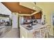 Bright kitchen with stainless steel appliances, wooden cabinets and bar seating adjacent to the living room at 4446 Bahama Dr, Hernando Beach, FL 34607