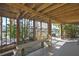 Covered outdoor patio featuring wood beam construction, seating, and serene canal views at 4446 Bahama Dr, Hernando Beach, FL 34607