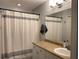 Well lit bathroom featuring neutral color scheme and a white striped shower curtain at 5520 Rosehill Rd # 201, Sarasota, FL 34233