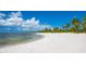 Picture of a beautiful white sand beach with calm blue waters and palm trees at 5520 Rosehill Rd # 201, Sarasota, FL 34233