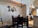 Dining area with modern lighting and a glimpse of the adjacent, updated kitchen at 5520 Rosehill Rd # 201, Sarasota, FL 34233