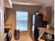 Cozy kitchen with stainless steel refrigerator, sink and view through window at 5520 Rosehill Rd # 201, Sarasota, FL 34233
