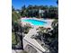 Community pool surrounded by lush landscaping and lounge chairs at 4939 Marina Palms Dr, Port Richey, FL 34668