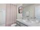 Bright bathroom featuring a granite vanity, a tub with shower and decorative artwork at 30926 Silver Stage Dr, Brooksville, FL 34602
