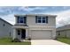 Charming two-story home with a two-car garage and beautiful blue shutters in a well manicured lawn at 30926 Silver Stage Dr, Brooksville, FL 34602