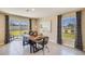 Modern dining room features a wooden table, bench seating, contemporary chairs, and sliding glass doors to the yard at 30934 Silver Stage Dr, Brooksville, FL 34602