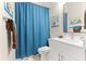 Bright bathroom with white vanity, modern fixtures, blue shower curtain and decorative wall art at 6771 Seaview Blvd, Hudson, FL 34667