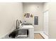 Bright laundry room featuring stainless steel sink, modern washer and dryer, and ample countertop space at 6771 Seaview Blvd, Hudson, FL 34667