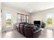 Living room with a ceiling fan, doors to a covered patio, and a dark brown leather couch at 6771 Seaview Blvd, Hudson, FL 34667