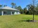 Spacious backyard with green grass, bordered by mature trees, perfect for outdoor activities at 1220 Gantry Rd, North Port, FL 34288