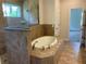 Elegant bathroom featuring a soaking tub, tiled surround, and glass-enclosed shower, creating a luxurious spa-like experience at 1220 Gantry Rd, North Port, FL 34288