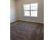 Bedroom features neutral carpet flooring and natural light from the large window at 1220 Gantry Rd, North Port, FL 34288