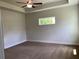 Neutral bedroom with a ceiling fan, carpet, and a window that provides natural light and a comfortable atmosphere at 1220 Gantry Rd, North Port, FL 34288