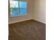 Bright bedroom featuring neutral carpet flooring and a large window with view at 1220 Gantry Rd, North Port, FL 34288