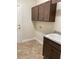 Functional laundry area with upper cabinets, granite countertop sink, and tile floors at 1220 Gantry Rd, North Port, FL 34288