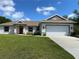 Charming single-Gathering home with a well-manicured lawn and a two-car garage on a sunny day at 1608 Alliance Ave, North Port, FL 34286