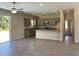 Open kitchen with stainless appliances, gray cabinets, granite counters, and tile floor at 1608 Alliance Ave, North Port, FL 34286