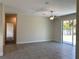 Spacious living room with tile floors, ceiling fan, and sliding glass doors leading to the backyard at 1608 Alliance Ave, North Port, FL 34286