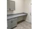 Home office features gray cabinets, granite countertop and neutral walls with tile flooring at 1608 Alliance Ave, North Port, FL 34286