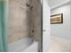 Bathroom with tiled shower, a bathtub, shower head and door to the next room at 17663 Turning Leaf Cir, Land O Lakes, FL 34638