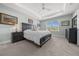 This bedroom features a tray ceiling, ceiling fan and an ensuite at 17663 Turning Leaf Cir, Land O Lakes, FL 34638