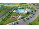 Aerial view showcases a community area with a pool, playground, parking, and green space at 17663 Turning Leaf Cir, Land O Lakes, FL 34638