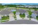 Aerial view of an exterior elevation showcasing a three car garage, pond view, and landscaping at 17663 Turning Leaf Cir, Land O Lakes, FL 34638