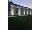 Beautiful home exterior featuring landscape lighting, a green lawn, and neutral stucco at 17663 Turning Leaf Cir, Land O Lakes, FL 34638