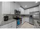Bright kitchen with stainless steel appliances, tile backsplash, granite countertops, and white cabinets at 17663 Turning Leaf Cir, Land O Lakes, FL 34638
