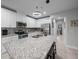 Modern kitchen features granite countertops, stainless appliances, island with bar seating, and a stylish tile backsplash at 17663 Turning Leaf Cir, Land O Lakes, FL 34638