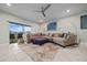 Comfortable living room with tile flooring, ceiling fan, and a large sectional couch at 17663 Turning Leaf Cir, Land O Lakes, FL 34638