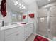 Main bathroom featuring a double vanity with white cabinets and a tiled walk-in shower at 17663 Turning Leaf Cir, Land O Lakes, FL 34638
