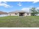 Expansive backyard view showing well-maintained lawn and covered patio with outdoor seating at 4196 Hoffman Ave, Spring Hill, FL 34606