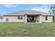 Home's backyard featuring a covered patio, well-kept lawn, and exterior of the house at 4196 Hoffman Ave, Spring Hill, FL 34606