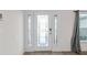 Elegant front door features decorative glass sidelights, leading to a light and airy home interior at 4196 Hoffman Ave, Spring Hill, FL 34606