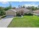 Charming single-story home with a manicured front yard, large driveway, and attached two-car garage at 4196 Hoffman Ave, Spring Hill, FL 34606