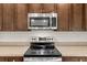Modern kitchen appliances and countertops with brown cabinets at 4196 Hoffman Ave, Spring Hill, FL 34606