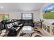 Comfortable living room featuring a large leather sectional couch, decorative rug and lots of natural light at 4196 Hoffman Ave, Spring Hill, FL 34606