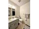 A well-lit bathroom with a single sink vanity, toilet, decorative towels, and neutral tile flooring at 4622 Blossom Blvd # D, Zephyrhills, FL 33542