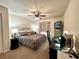 This bedroom features an overhead fan, wall-mounted TV, and computer set-up for a multi-use living space at 4622 Blossom Blvd # D, Zephyrhills, FL 33542