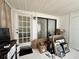 Sunroom with light walls, sliding glass door, a glass paneled door and contents in need of organizing at 4622 Blossom Blvd # D, Zephyrhills, FL 33542