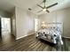 Spacious bedroom with wood floors, ceiling fan and a floral bed set at 6212 Abbott Station Dr, Zephyrhills, FL 33542
