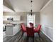 Bright dining area with red upholstered chairs, wood flooring, and an ornate chandelier at 6212 Abbott Station Dr, Zephyrhills, FL 33542