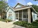 Light blue home with cream trim, a screened porch, and small decorative front garden at 6212 Abbott Station Dr, Zephyrhills, FL 33542