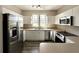 Modern kitchen featuring stainless steel appliances, white cabinetry, and wood flooring at 6212 Abbott Station Dr, Zephyrhills, FL 33542