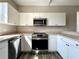 Modern kitchen featuring stainless steel appliances and white cabinets at 6212 Abbott Station Dr, Zephyrhills, FL 33542