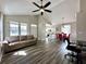 Open concept living room with wood floors, vaulted ceiling, and lots of natural light at 6212 Abbott Station Dr, Zephyrhills, FL 33542