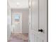 Bright hallway featuring wood-look flooring, white walls, and a door with glass panels at 13024 Dania St, Hudson, FL 34667