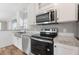 Modern kitchen with stainless steel appliances, granite countertops, and white cabinetry at 13024 Dania St, Hudson, FL 34667