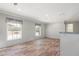 Open living room with wood-look floors, natural light, and neutral color palette at 13024 Dania St, Hudson, FL 34667